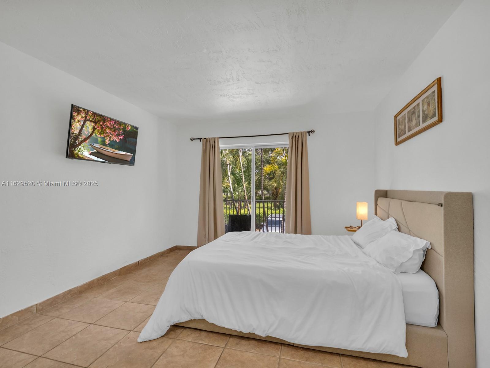 7403 Southwest 82nd Street, Unit 201N Miami, FL 33143 - Photo 24 of 43 a bedroom with a bed and a window