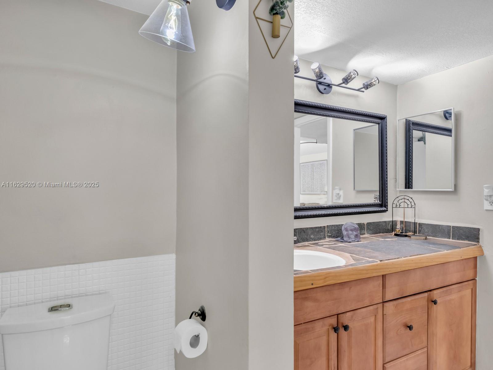 7403 Southwest 82nd Street, Unit 201N Miami, FL 33143 - Photo 27 of 43 a bathroom with a double vanity sink and mirror