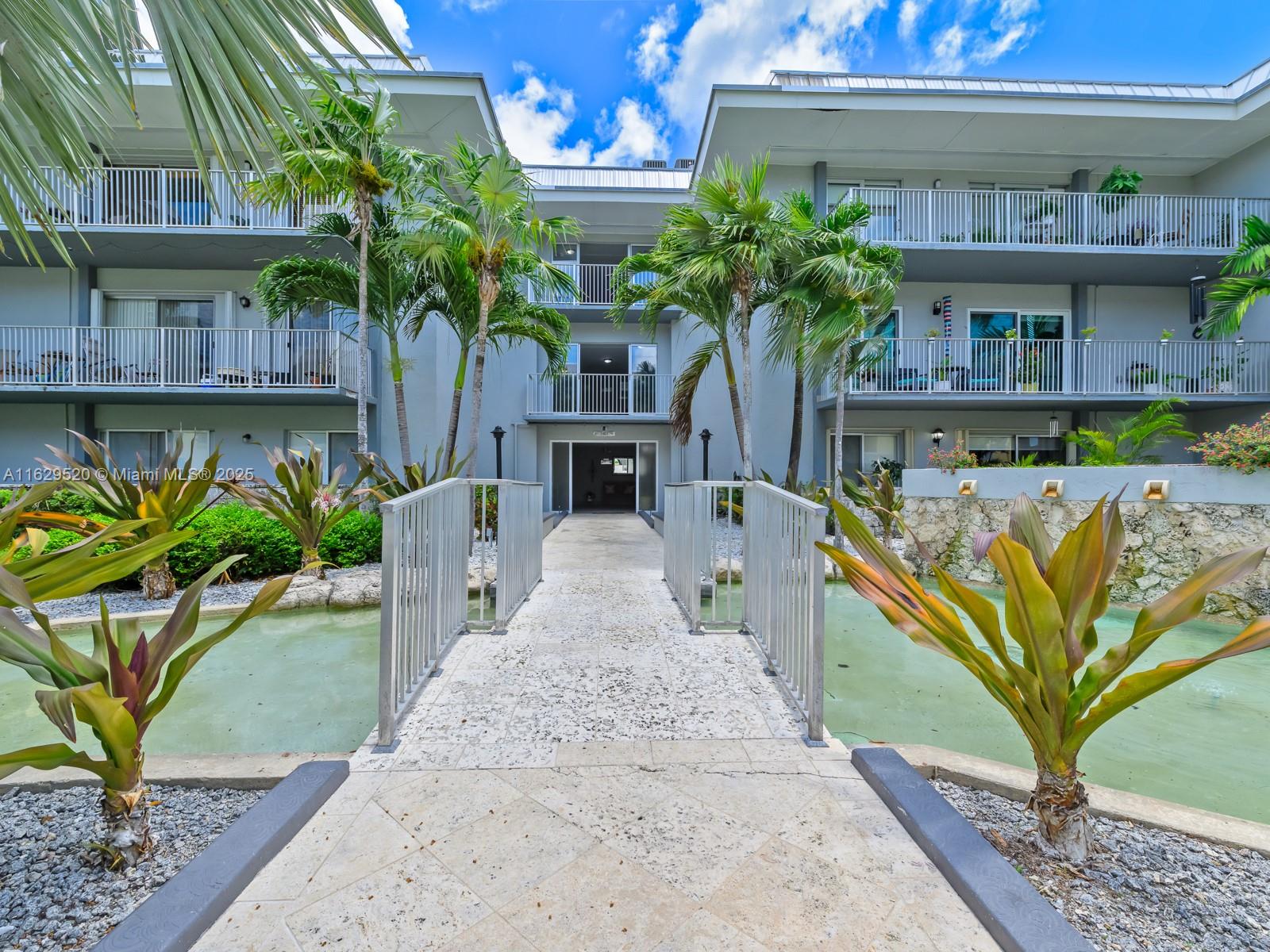 7403 Southwest 82nd Street, Unit 201N Miami, FL 33143 - Photo 7 of 43 a view of a house with a small yard and potted plants