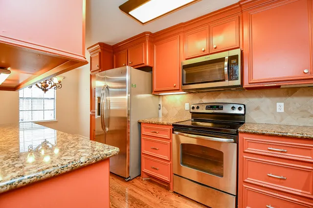 a kitchen with stainless steel appliances granite countertop a stove a microwave and a sink