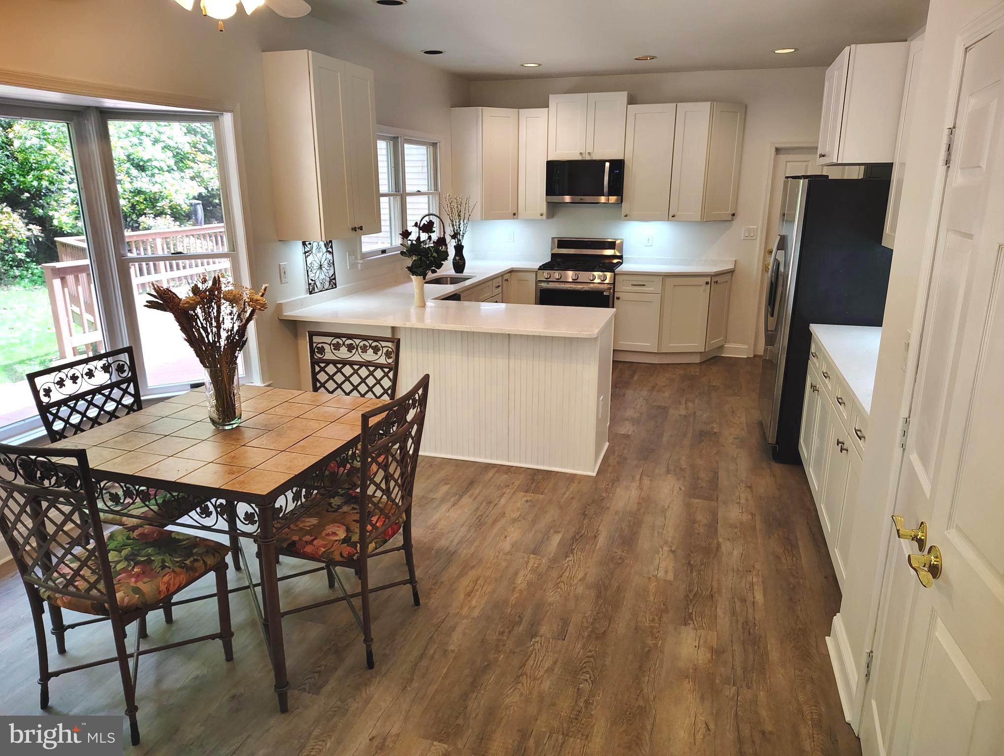 1711 Ritchie Highway Annapolis, MD 21409 - Photo 10 of 16 a kitchen with stainless steel appliances granite countertop a kitchen island hardwood floor a dining table and chairs