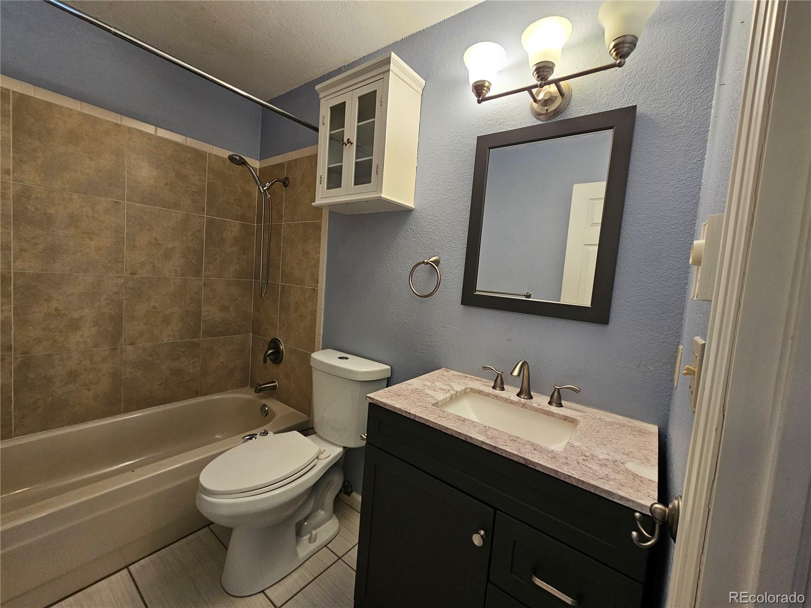 16985 Sage Crest Road Peyton, CO 80831 - Photo 15 of 25 a bathroom with a toilet a sink a mirror a bathtub and vanity