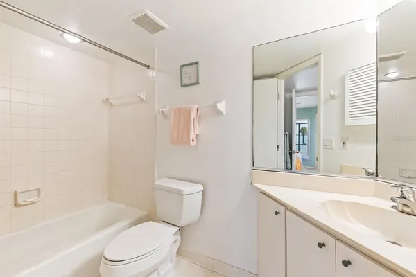 a bathroom with a toilet a sink a mirror a bathtub and shower