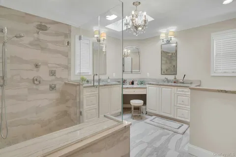 a bathroom with a sink a toilet a mirror and shower