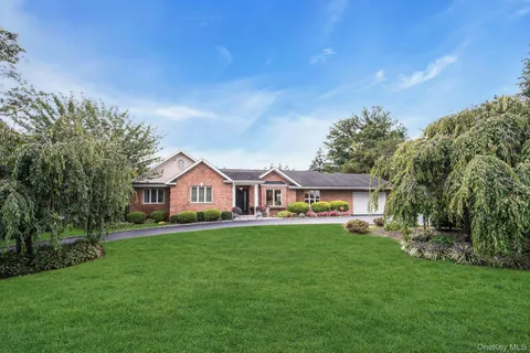 a front view of a house with a garden and trees