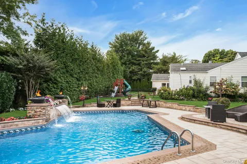 swimming pool view with a seating space and a garden