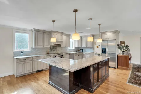 a kitchen with granite countertop a sink stove and refrigerator