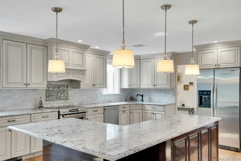 a kitchen with kitchen island a counter space a sink appliances and cabinets