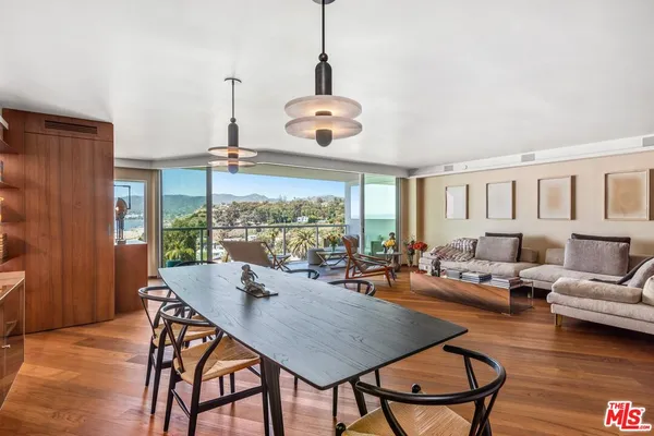a dining room with furniture a chandelier and wooden floor