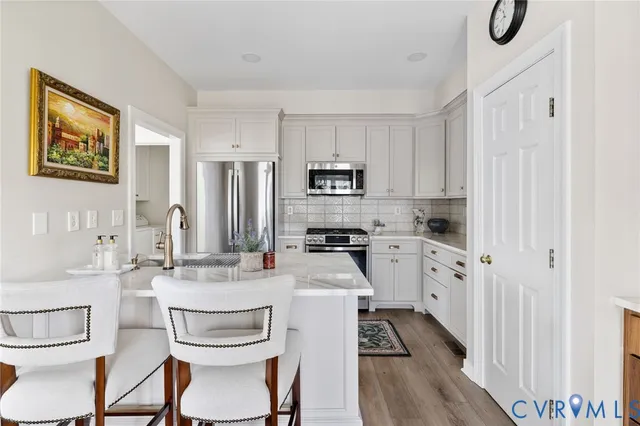 a kitchen with white cabinets and stainless steel appliances