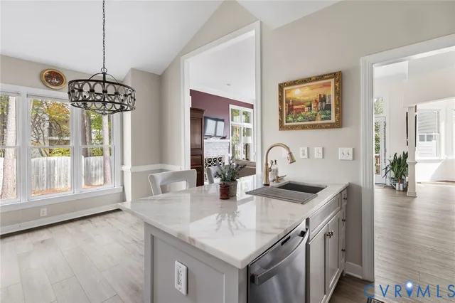 a kitchen with granite countertop a stove a sink a dining table and chairs