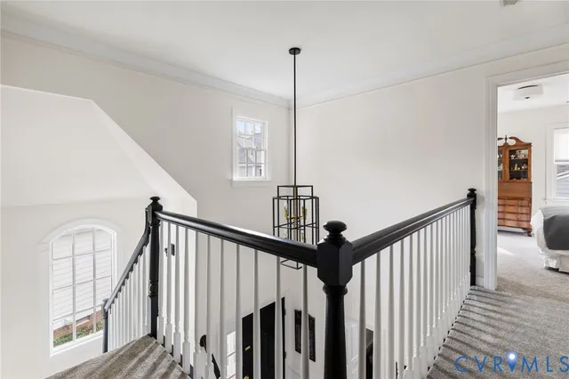a view of a hallway with wooden floor and stairs