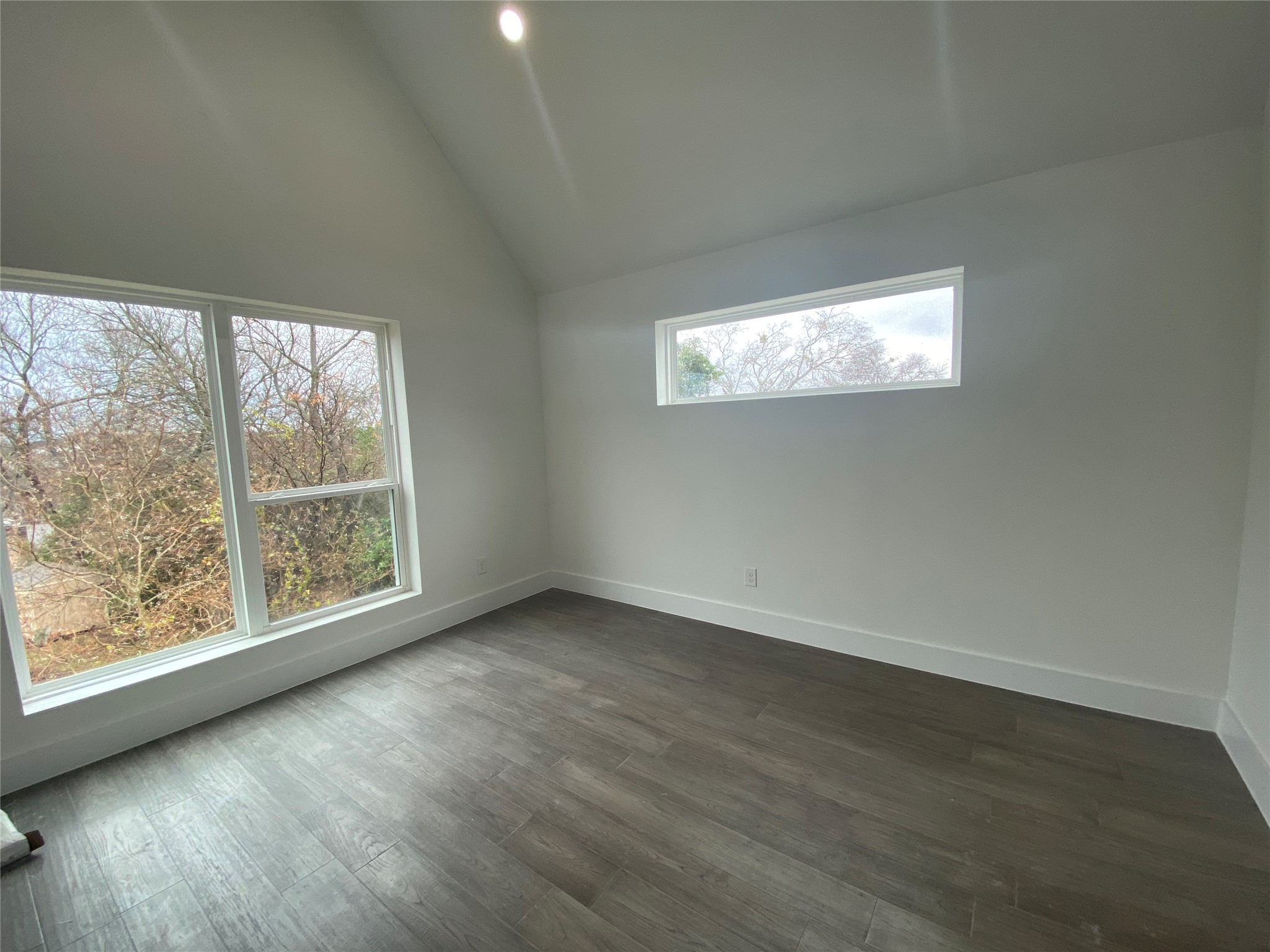 1916 Webberville Road, Unit B Austin, TX 78721 - Photo 15 of 25 Vaulted ceiling room with wood-finish flooring, recessed lighting, and white baseboards