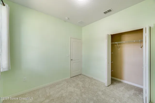 an empty room with a ceiling fan and window
