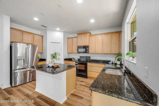 a kitchen with refrigerator a stove a sink dishwasher with a dining table and chairs