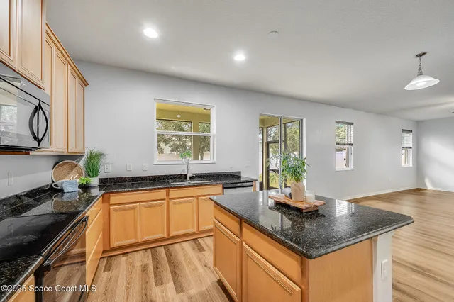 a kitchen with stainless steel appliances granite countertop a sink stove and cabinets