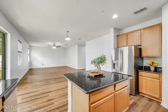 a kitchen with stainless steel appliances granite countertop sink refrigerator and cabinets
