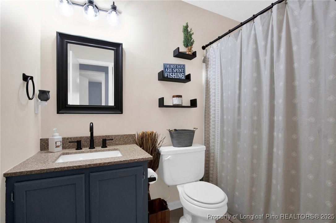 156 Barefoot Road Fayetteville, NC 28306 - Photo 17 of 28 a bathroom with a toilet sink and mirror