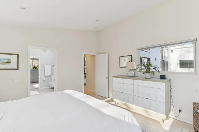 a spacious bedroom with a bed and a dresser