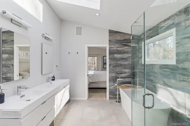 a bathroom with a tub sink and mirror