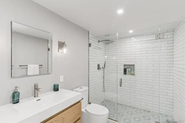 a bathroom with a sink a toilet and shower