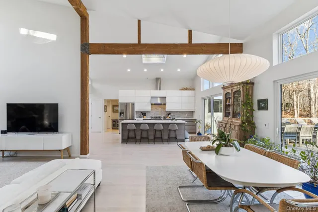 a living room with furniture a flat screen tv and kitchen view