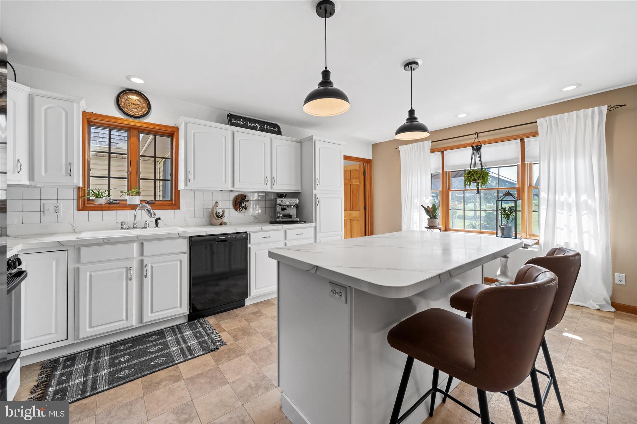 1265 Bowman Road Milford, DE 19963 - Photo 17 of 60 a kitchen with a stove a sink a dining table and chairs