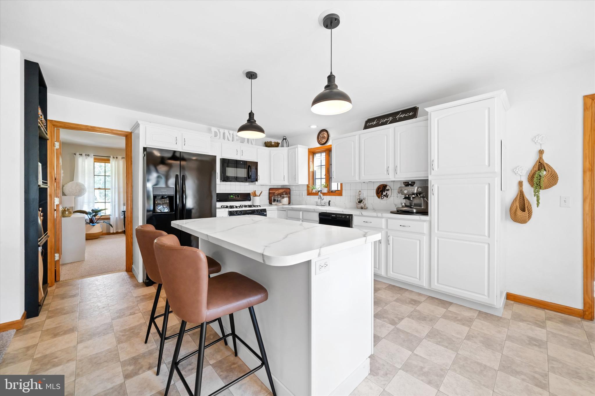 1265 Bowman Road Milford, DE 19963 - Photo 20 of 60 a kitchen with stainless steel appliances kitchen island granite countertop a table chairs and a refrigerator