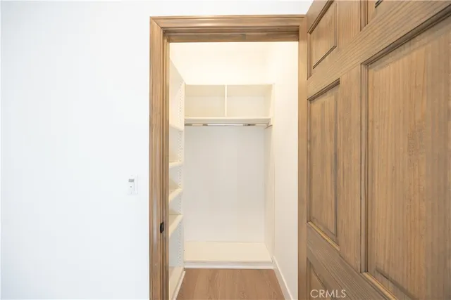 a view of a hallway with wooden floor and windows