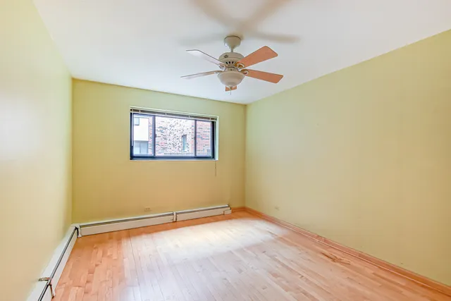 an empty room with a window and a ceiling fan