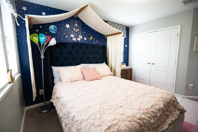 a large bed sitting in a bedroom next to a window