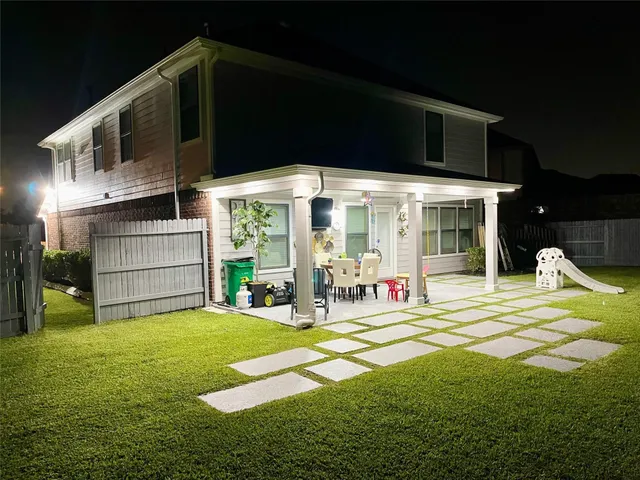 a view of a chair and tables in backyard of the house