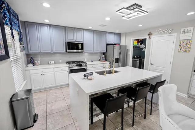 a kitchen with a sink a stove a refrigerator and cabinets