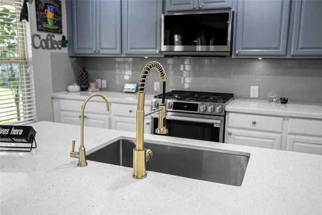a kitchen with granite countertop a stove and a sink