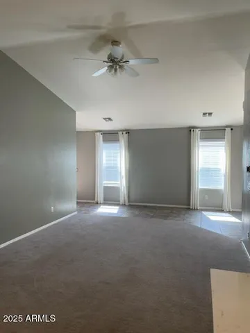 a view of a room with a ceiling fan and window