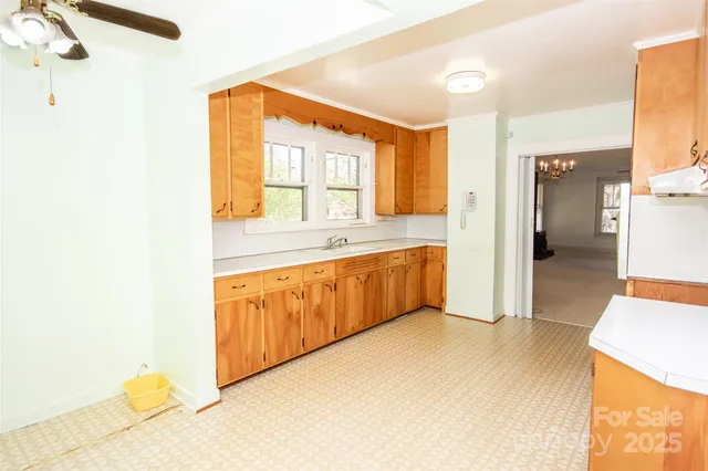 a large white kitchen with a sink a refrigerator and a stove