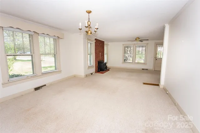 an empty room with windows and chandelier