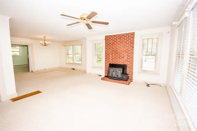 a view of an empty room with a fireplace and a window