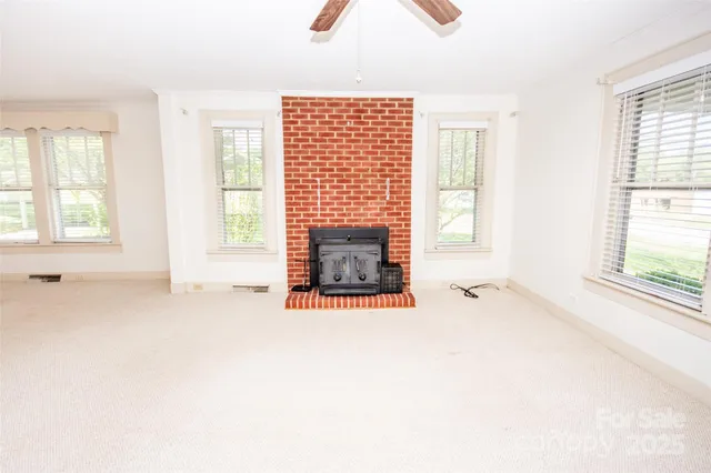 a view of an empty room with a fireplace and a window