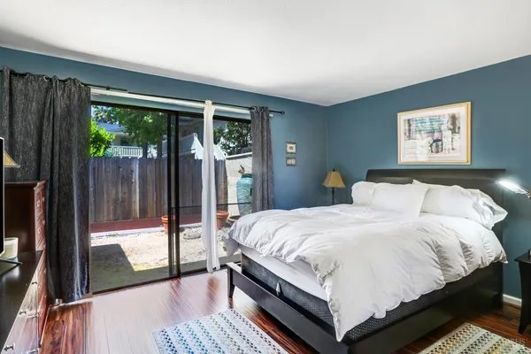a bedroom with a bed lamp and large window