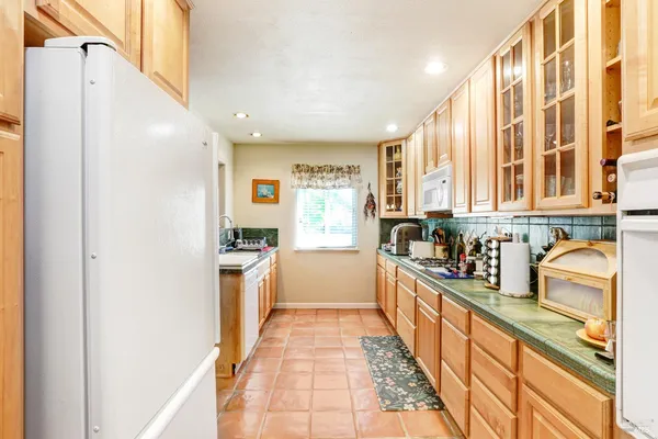 a large kitchen with stainless steel appliances granite countertop a refrigerator and a sink