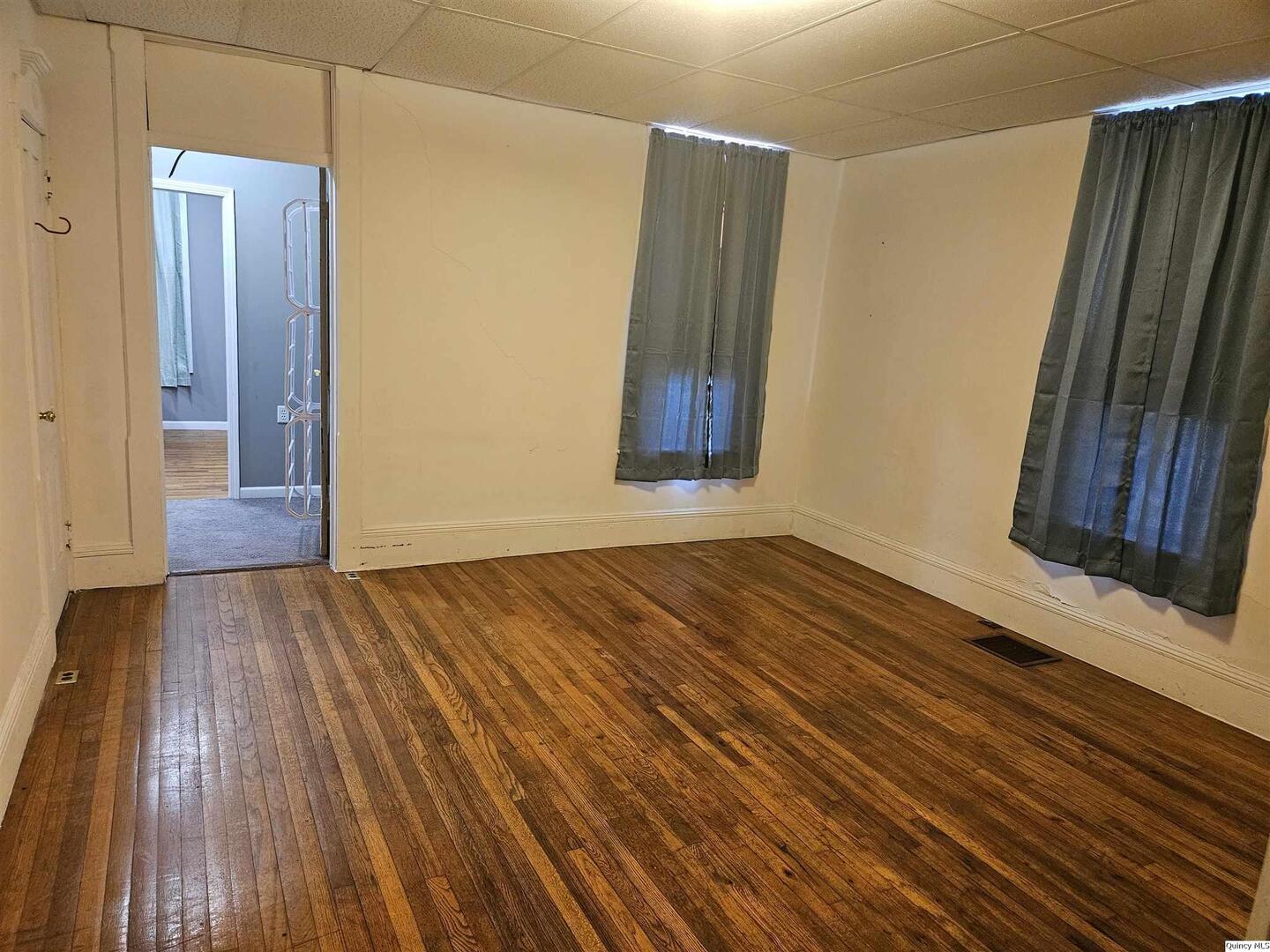 933 Adams Street Quincy, IL 62301 - Photo 15 of 26 a view of an empty room with wooden floor and a window
