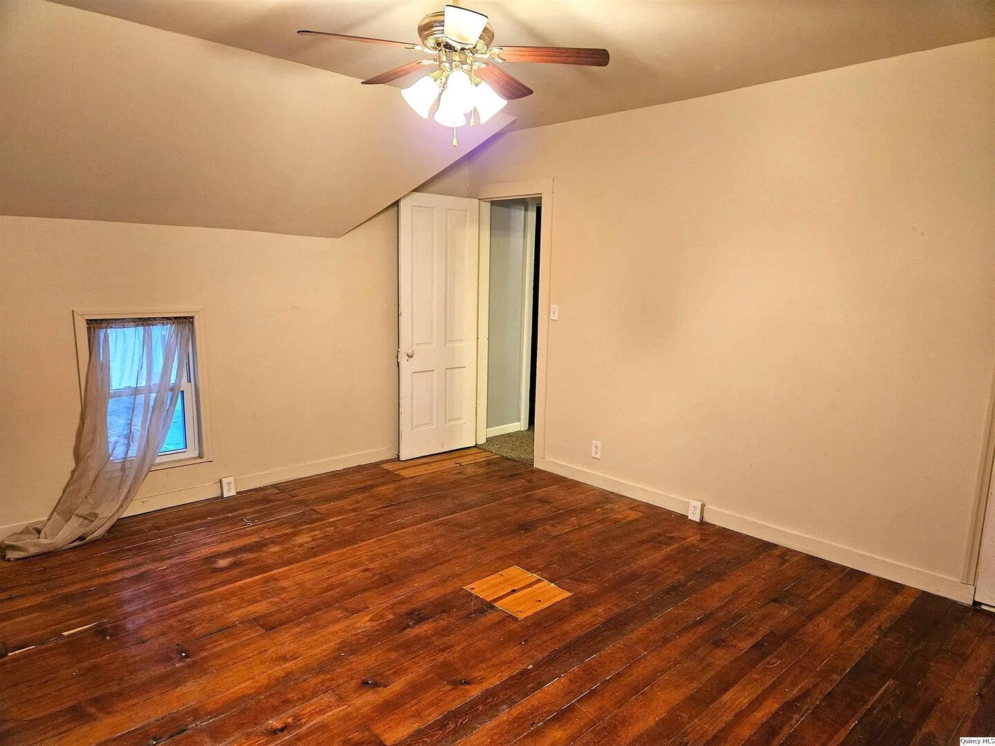 933 Adams Street Quincy, IL 62301 - Photo 25 of 26 a view of an empty room with wooden floor and a ceiling fan
