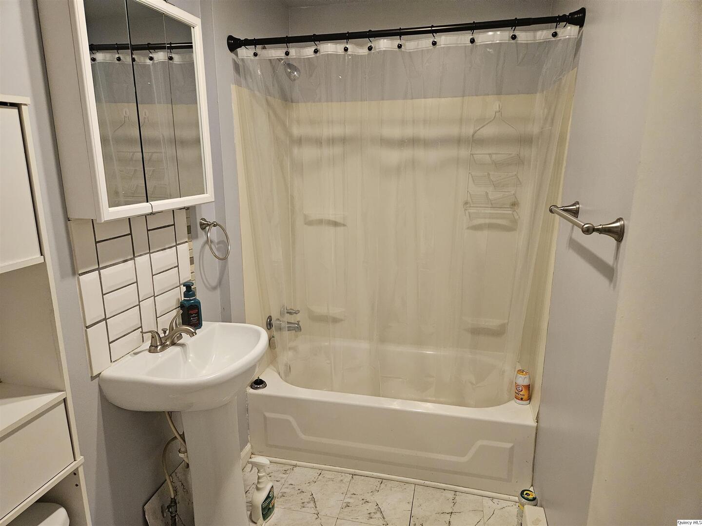 933 Adams Street Quincy, IL 62301 - Photo 26 of 26 a bathroom with a sink a mirror a bathtub and shower