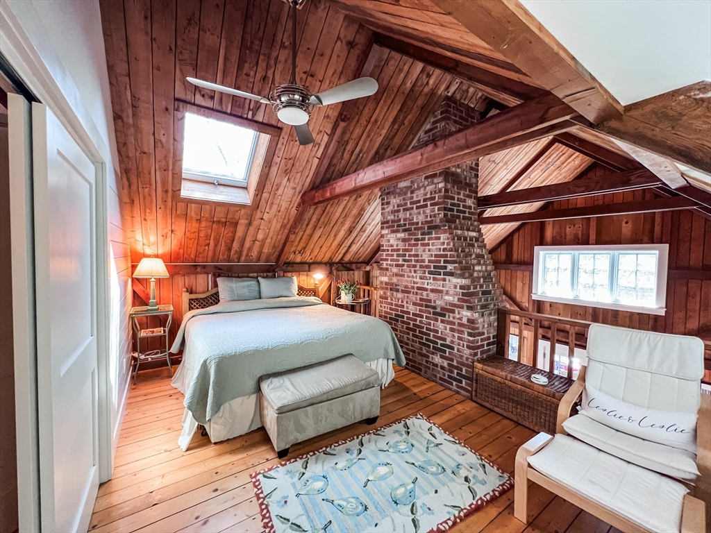 225 Lamberts Cove Road West Tisbury, MA 02568 - Photo 21 of 33 a bedroom with a bed and wooden floor