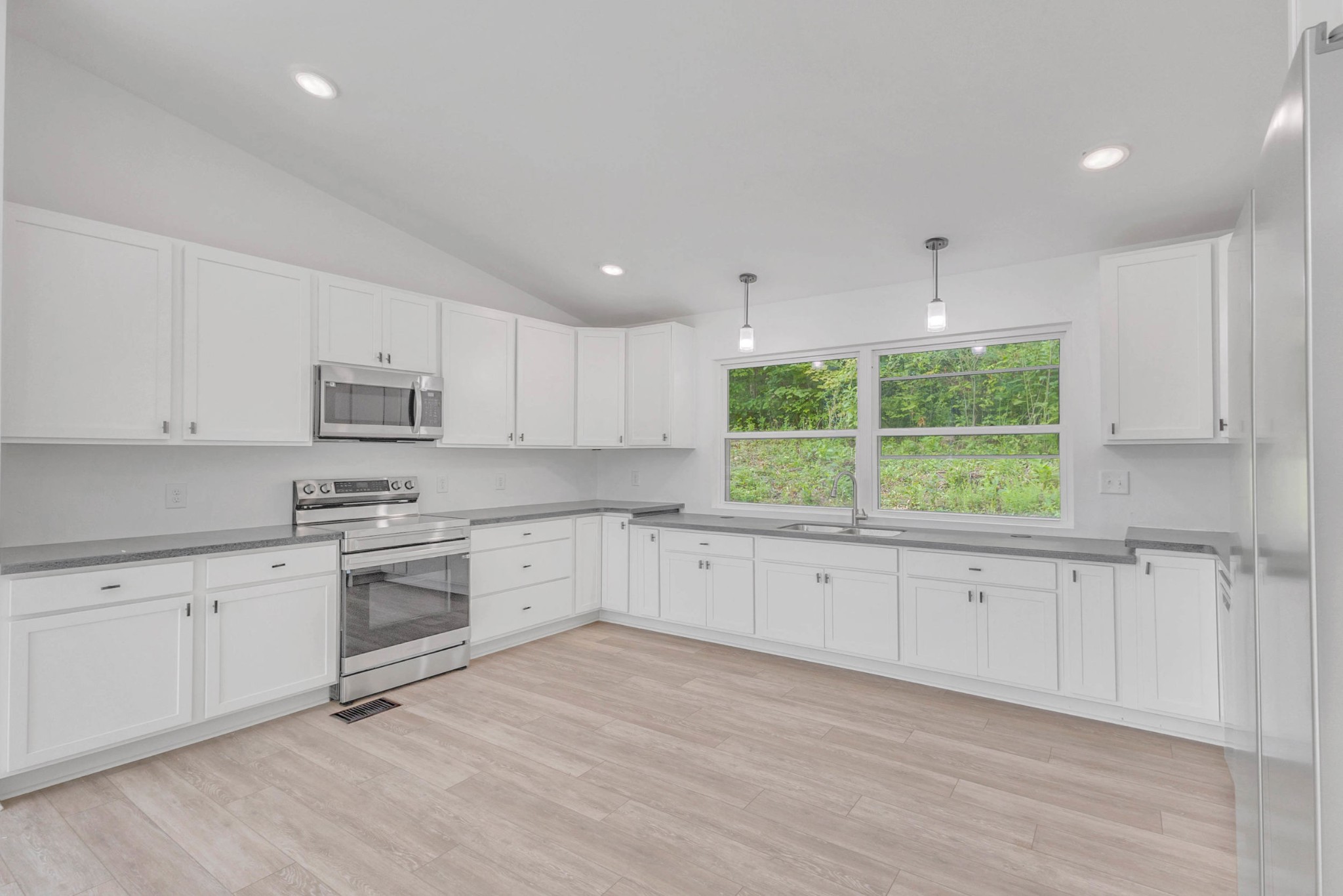 515 Big Branch Road Granville, TN 38564 - Photo 17 of 76 a large white kitchen with granite countertop white cabinets and a wooden floor