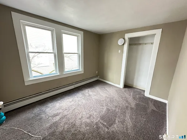 an empty room with windows and closet