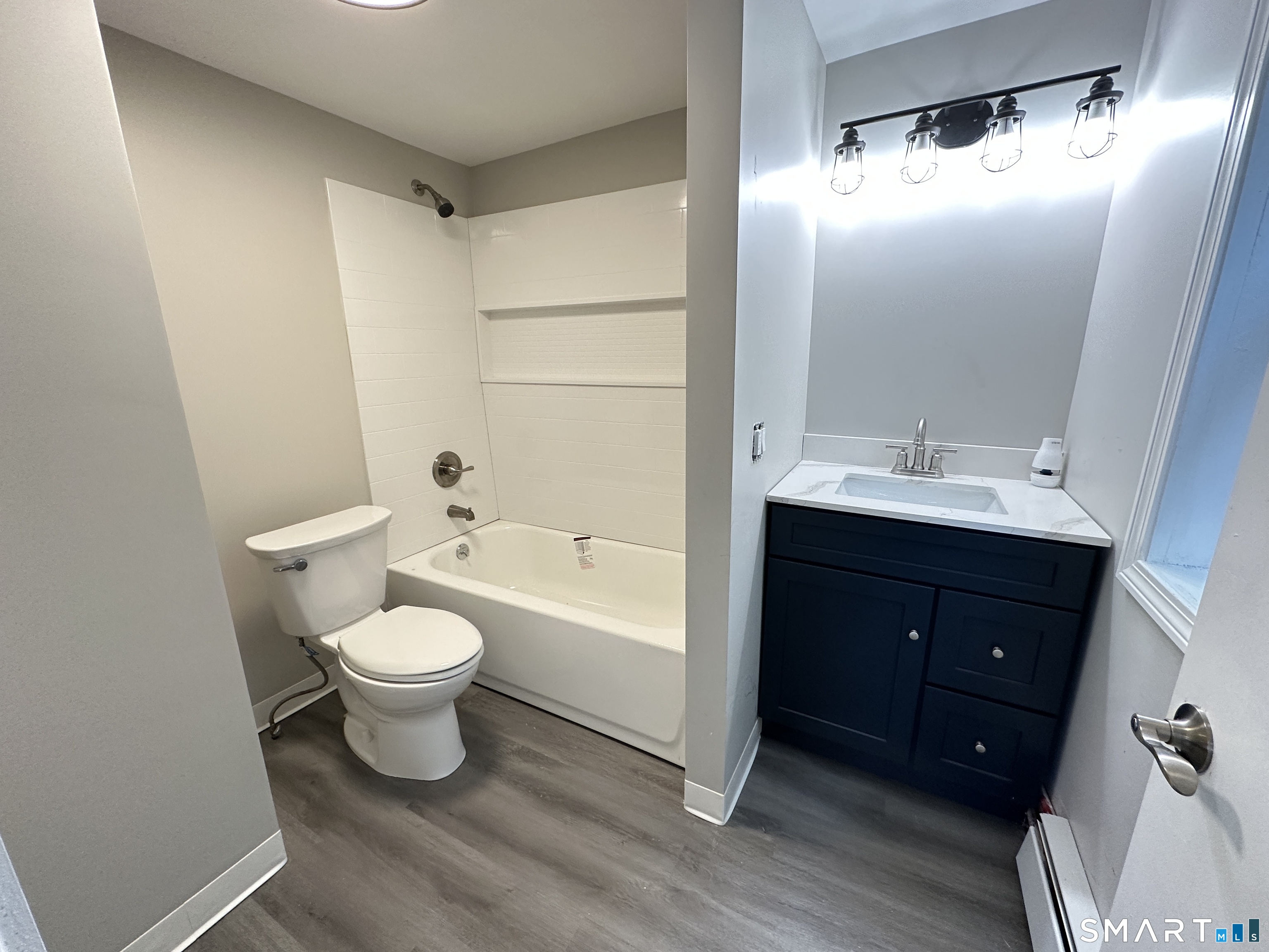 40 Oak Street, Unit 1 Windsor Locks, CT 06096 - Photo 15 of 21 a bathroom with a bathtub shower sink vanity and toilet