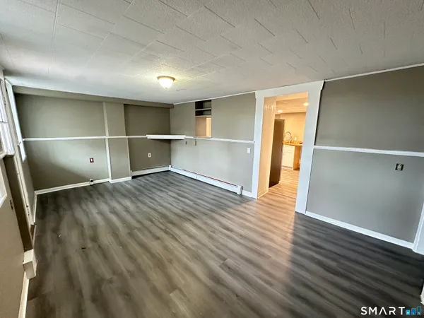 a view of an empty room with wooden floor