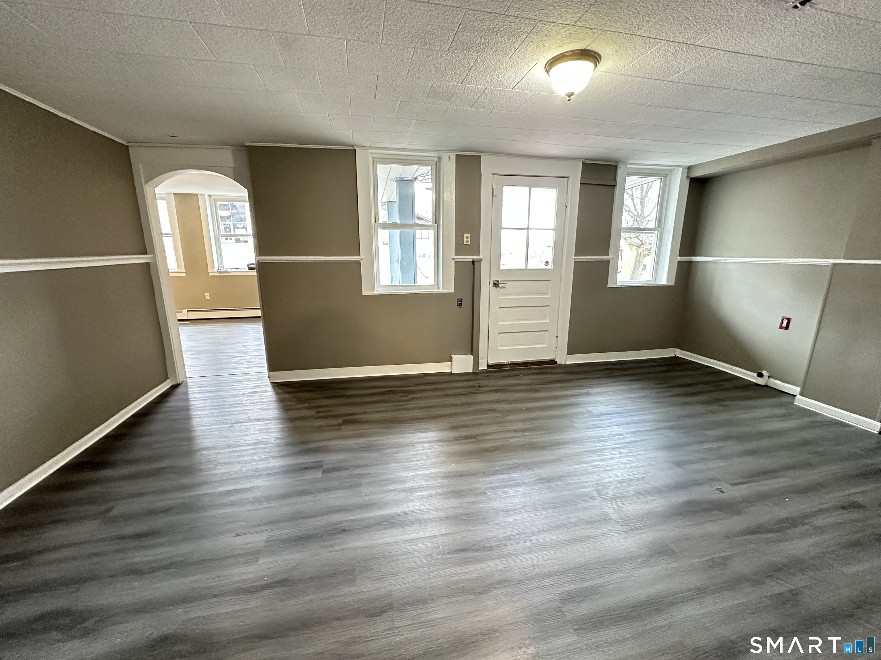 40 Oak Street, Unit 1 Windsor Locks, CT 06096 - Photo 5 of 21 an empty room with wooden floor and windows